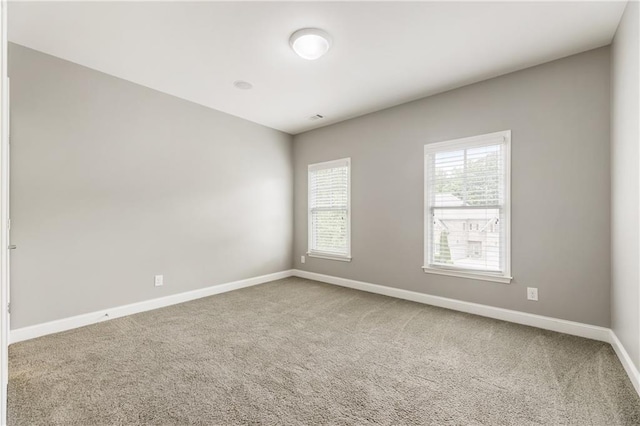 spare room with carpet and baseboards
