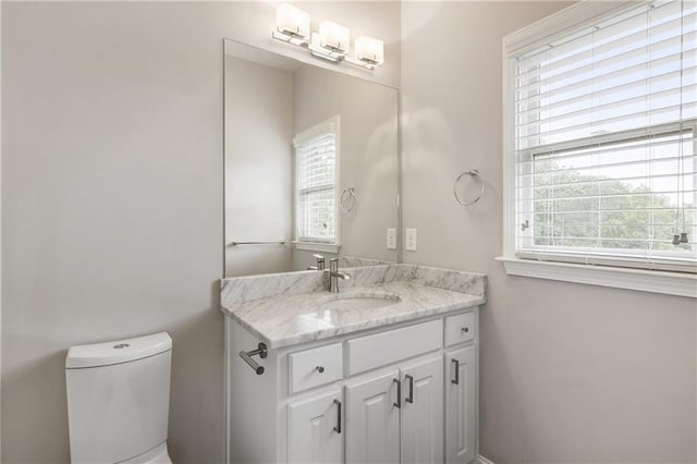 bathroom featuring plenty of natural light, toilet, and vanity