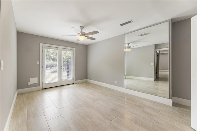 empty room featuring ceiling fan, french doors, baseboards, and light wood-style flooring