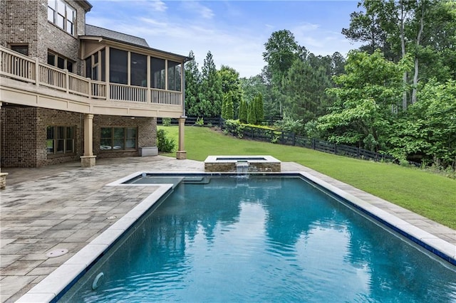view of swimming pool featuring a sunroom, a patio, and a pool with connected hot tub