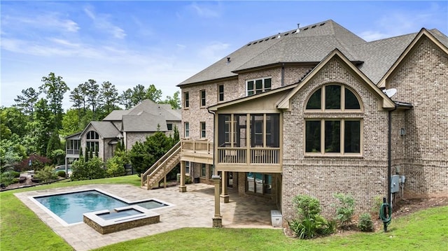 rear view of house featuring a sunroom, a patio area, stairs, a yard, and brick siding