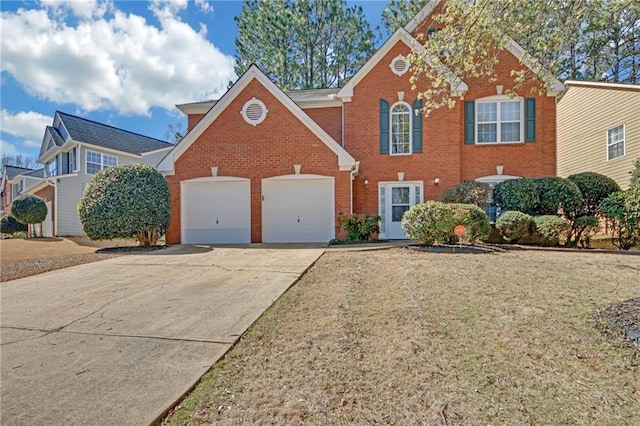 colonial inspired home with an attached garage, brick siding, concrete driveway, and a front yard