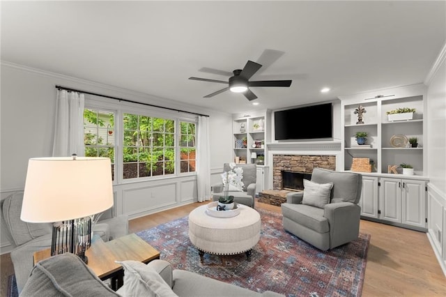 4433 Windsor Oaks Cir, Marietta, GA 30066 - living area featuring light wood finished floors, ornamental molding, a stone fireplace, ceiling fan, and built in shelves