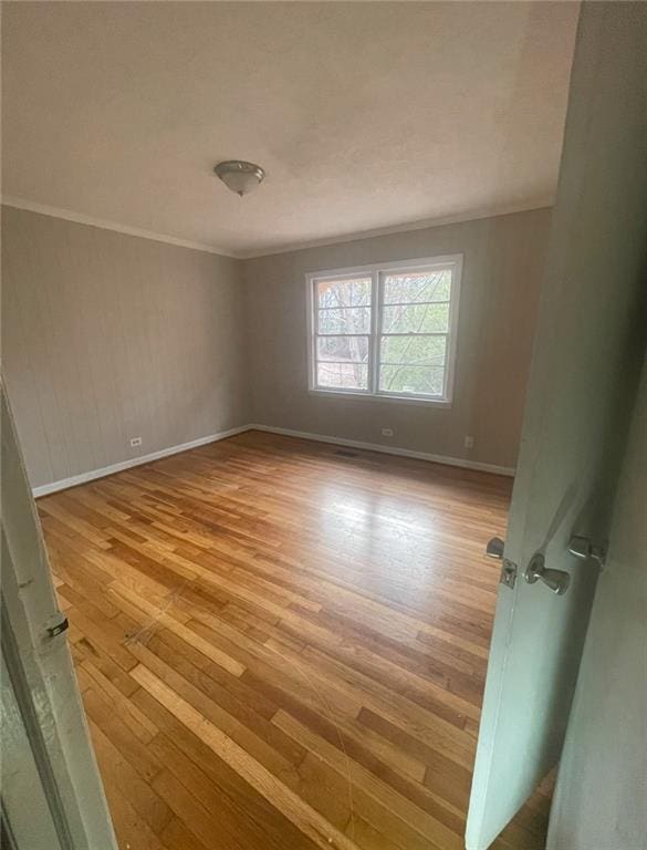 unfurnished room featuring crown molding and light hardwood / wood-style flooring