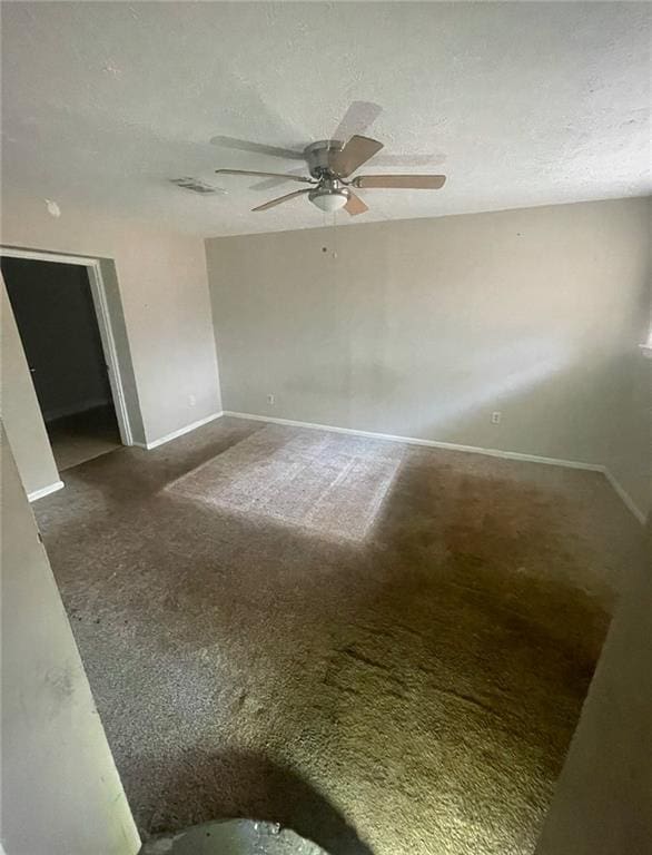 carpeted empty room with ceiling fan and a textured ceiling