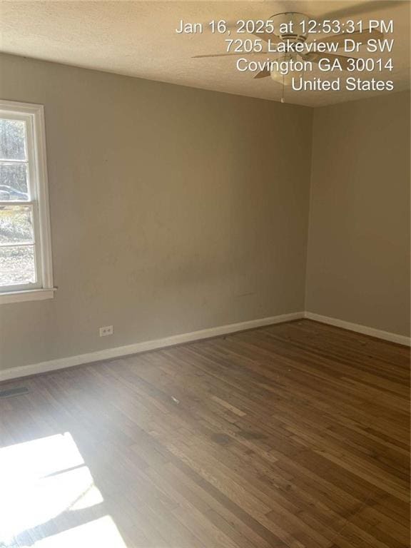 empty room featuring dark hardwood / wood-style floors and a textured ceiling