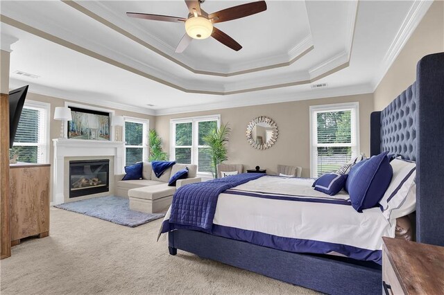 bedroom featuring ornamental molding, multiple windows, ceiling fan, and light colored carpet