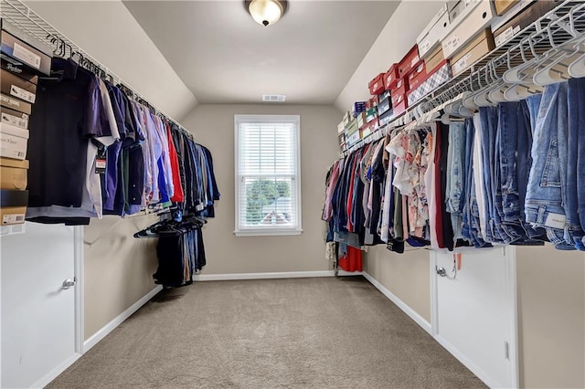 walk in closet featuring lofted ceiling and carpet floors