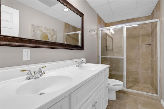 bathroom featuring tile patterned flooring, a shower with shower door, vanity, and toilet