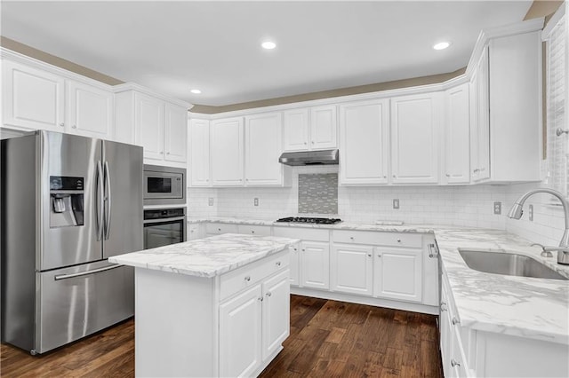 kitchen with sink, white cabinetry, appliances with stainless steel finishes, dark hardwood / wood-style floors, and a center island