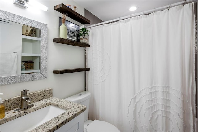 bathroom featuring walk in shower, vanity, and toilet