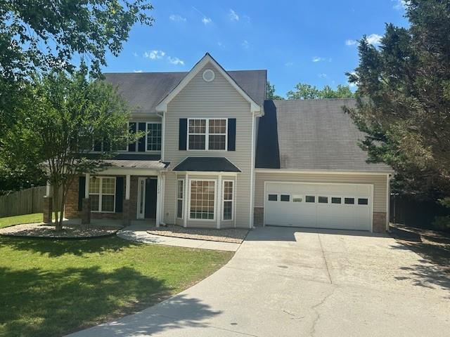 1732 Wyntercreek Ln, Hoschton, GA 30548 - traditional-style home featuring a garage, a front lawn, and driveway
