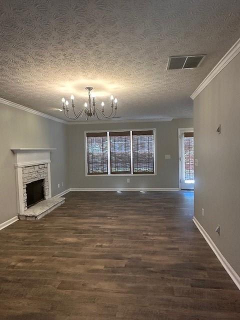 1732 Wyntercreek Ln, Hoschton, GA 30548 - unfurnished living room with ornamental molding, a chandelier, visible vents, and a textured ceiling