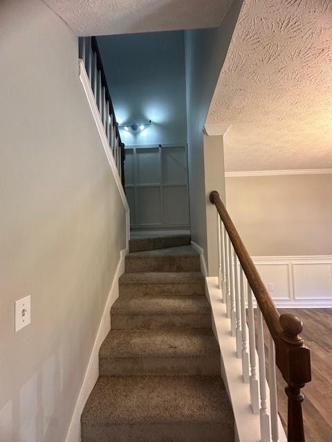 1732 Wyntercreek Ln, Hoschton, GA 30548 - stairs with wainscoting, a decorative wall, and a textured ceiling