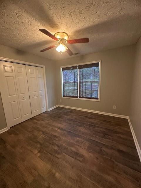 1732 Wyntercreek Ln, Hoschton, GA 30548 - unfurnished bedroom featuring a closet, a textured ceiling, ceiling fan, dark wood-style floors, and baseboards