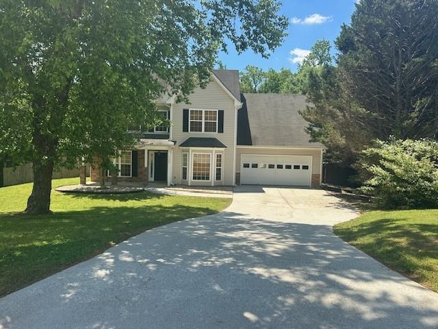 1732 Wyntercreek Ln, Hoschton, GA 30548 - traditional home featuring an attached garage, driveway, and a front lawn