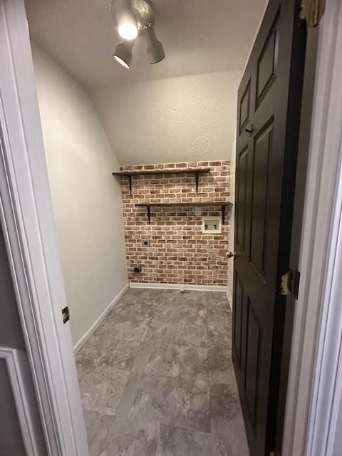 1732 Wyntercreek Ln, Hoschton, GA 30548 - hallway with brick wall, lofted ceiling, and baseboards