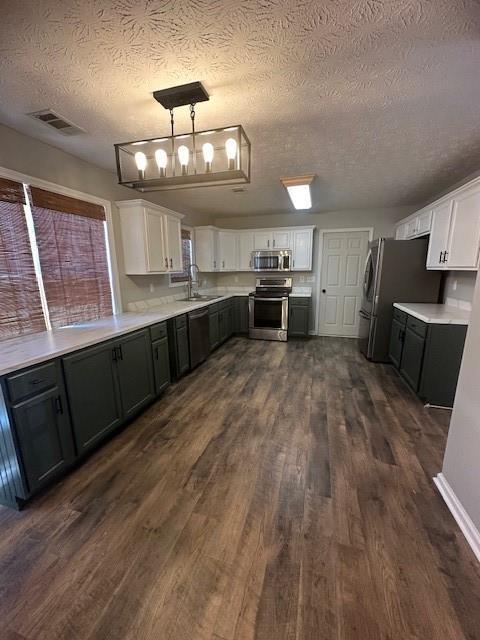 1732 Wyntercreek Ln, Hoschton, GA 30548 - kitchen featuring a textured ceiling, visible vents, a sink, stainless steel appliances, and white cabinets