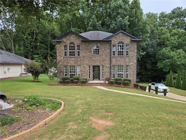 colonial-style house with brick siding, a front lawn, and roof with shingles