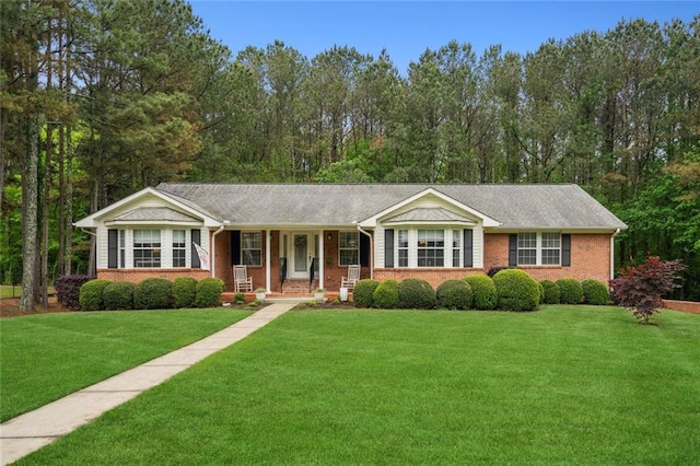 ranch-style house with covered porch, a front lawn, and brick siding