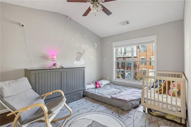 bedroom featuring hardwood / wood-style flooring, vaulted ceiling, and ceiling fan