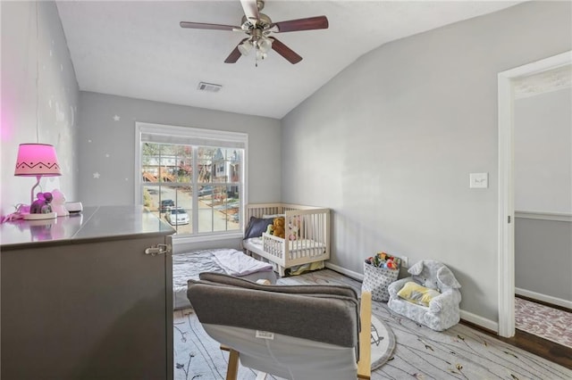 living area with ceiling fan, vaulted ceiling, and hardwood / wood-style flooring