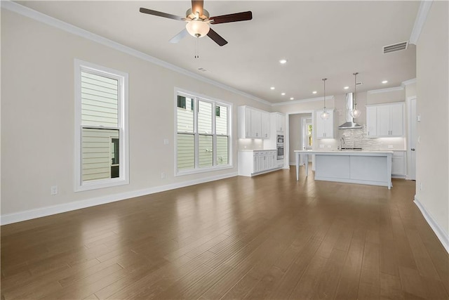636 Silva St, Cumming, GA 30040 - unfurnished living room with ceiling fan, ornamental molding, dark wood-type flooring, baseboards, and a sink