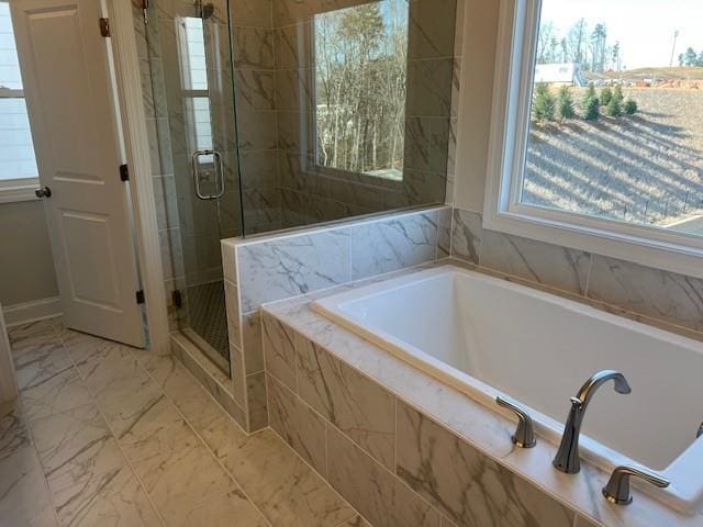 full bath featuring baseboards, a shower stall, a garden tub, and marble finish floor