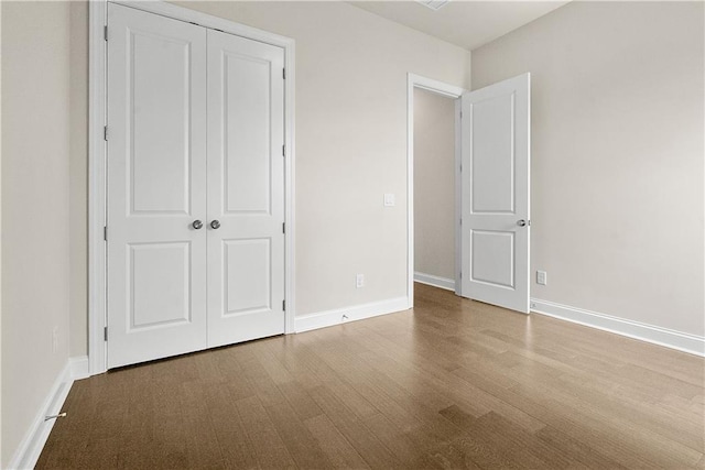 636 Silva St, Cumming, GA 30040 - unfurnished bedroom featuring wood finished floors, a closet, and baseboards