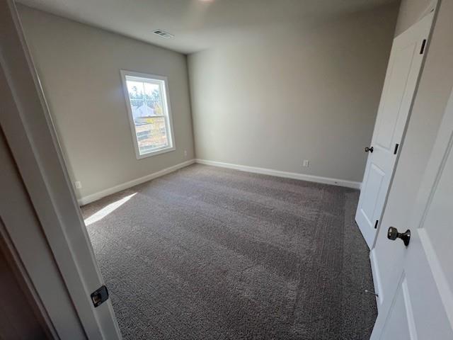 unfurnished bedroom featuring baseboards, visible vents, and carpet
