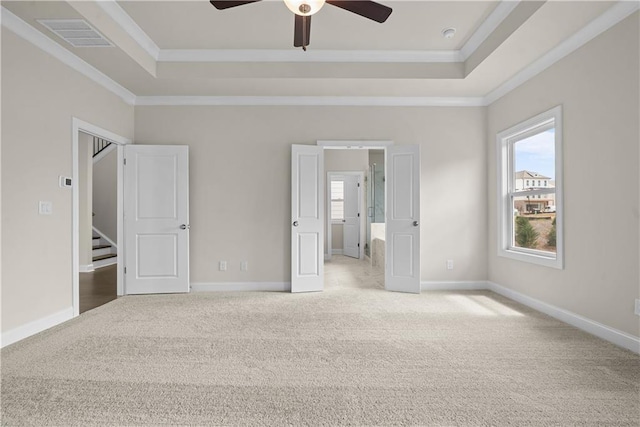 636 Silva St, Cumming, GA 30040 - unfurnished bedroom with a tray ceiling, light colored carpet, multiple windows, and crown molding