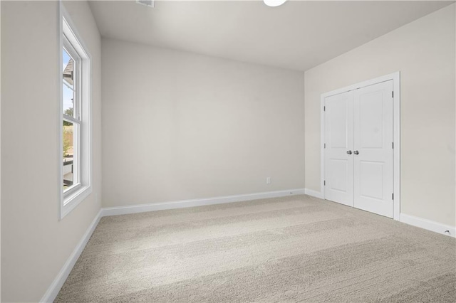 636 Silva St, Cumming, GA 30040 - unfurnished bedroom featuring multiple windows, light carpet, baseboards, and a closet