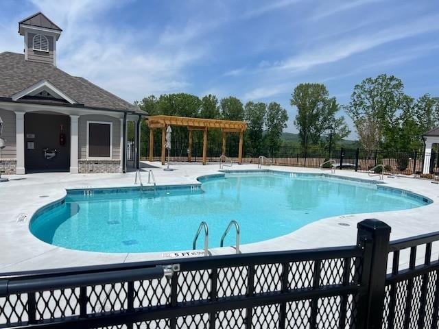 pool featuring fence, a pergola, and a patio area