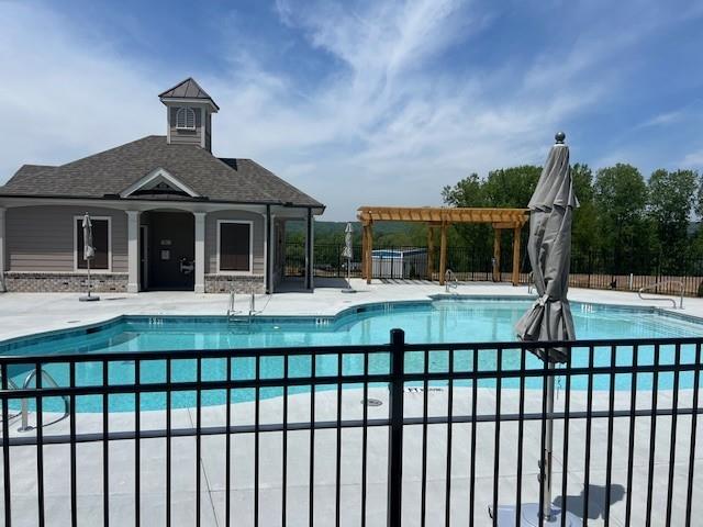 community pool featuring fence and a patio