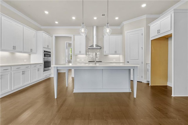 636 Silva St, Cumming, GA 30040 - kitchen with wall chimney exhaust hood, decorative backsplash, light countertops, crown molding, and white cabinetry