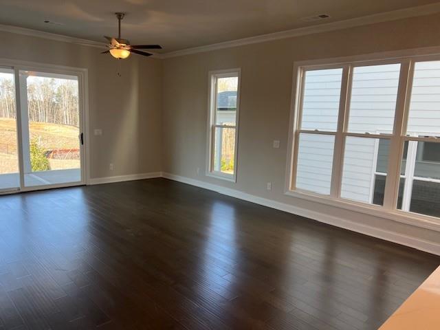 unfurnished room featuring baseboards, ornamental molding, and dark wood finished floors