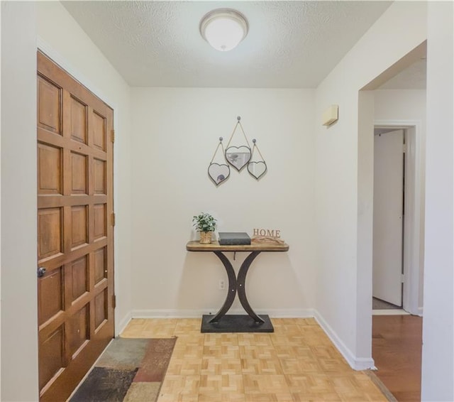 entryway featuring a textured ceiling and light parquet flooring