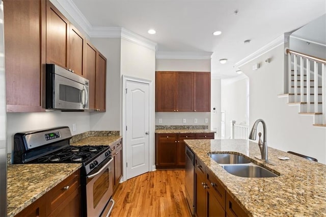 kitchen featuring sink, stainless steel appliances, ornamental molding, light hardwood / wood-style floors, and light stone countertops