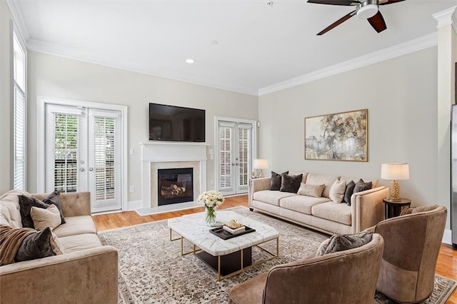 living room featuring french doors, ornamental molding, and light hardwood / wood-style flooring