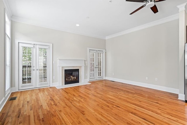 unfurnished living room with french doors, ornamental molding, and light hardwood / wood-style flooring