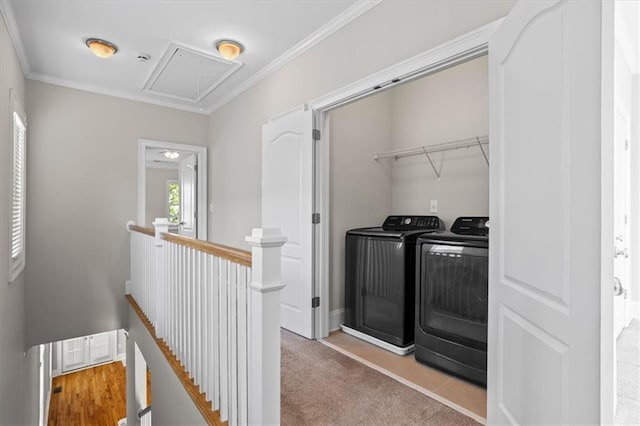 laundry room with washing machine and clothes dryer, ornamental molding, and light colored carpet