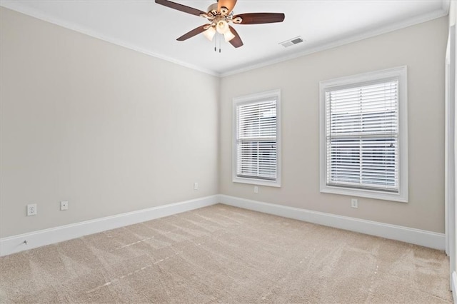 carpeted spare room featuring crown molding, ceiling fan, and a wealth of natural light