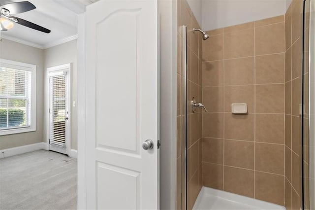 bathroom with ceiling fan, ornamental molding, and a shower with door