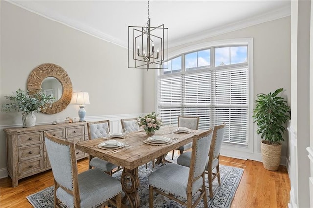 dining room with ornamental molding, a chandelier, and light wood-type flooring