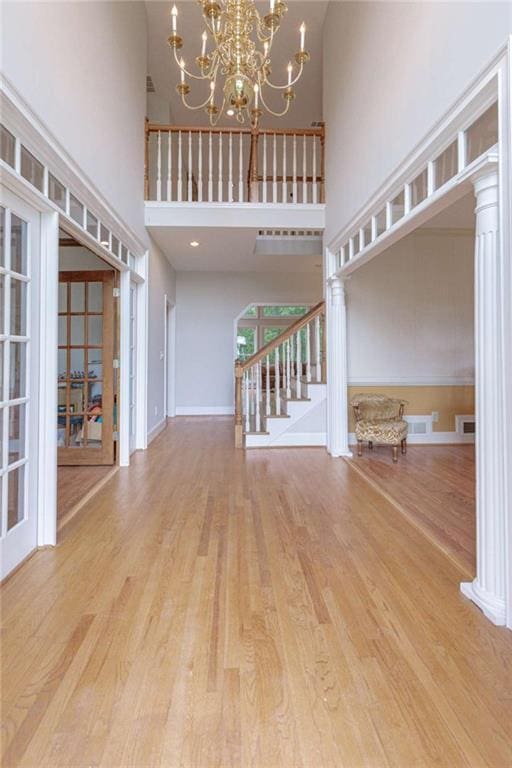 516 Turner Rd, Concord, GA 30206 - unfurnished living room featuring a high ceiling, stairway, wood finished floors, a chandelier, and baseboards