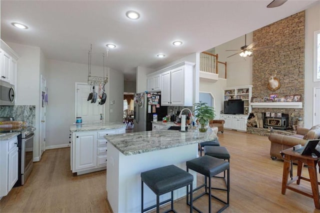 516 Turner Rd, Concord, GA 30206 - kitchen with stainless steel appliances, ceiling fan, a sink, a kitchen island, and decorative backsplash