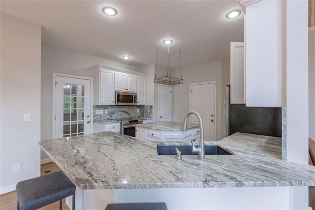 516 Turner Rd, Concord, GA 30206 - kitchen featuring stainless steel appliances, a sink, decorative backsplash, white cabinets, and light stone countertops