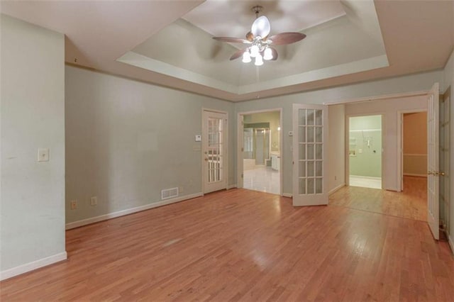 516 Turner Rd, Concord, GA 30206 - unfurnished room featuring a tray ceiling, a ceiling fan, light wood finished floors, baseboards, and french doors