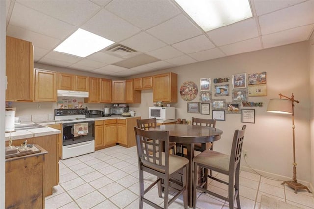 516 Turner Rd, Concord, GA 30206 - kitchen featuring white appliances, under cabinet range hood, a drop ceiling, light tile patterned floors, and tile countertops