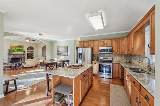 kitchen featuring appliances with stainless steel finishes, decorative backsplash, sink, a kitchen breakfast bar, and a center island